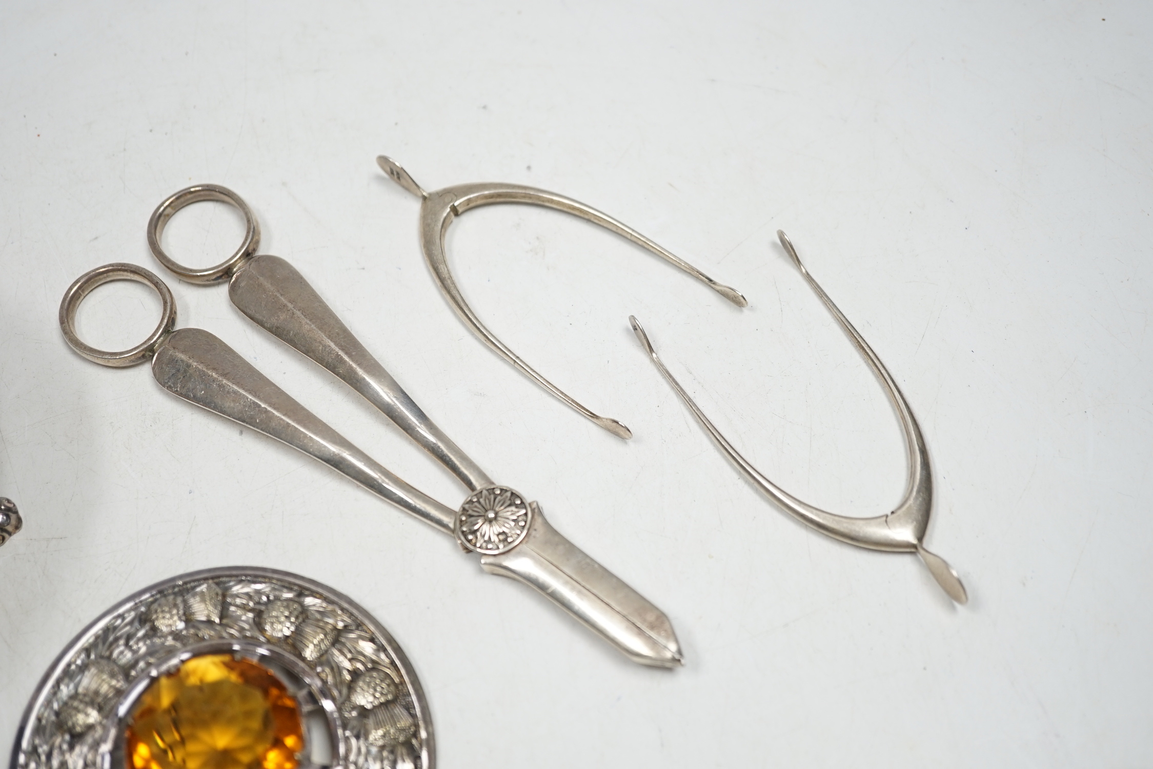 A pair of George V silver grape shears, Mappin & Webb, Sheffield, 1935, 17.2cm, four assorted pairs of early to mid 20th century silver wish bone sugar nips, a plated bowl and a brooch.